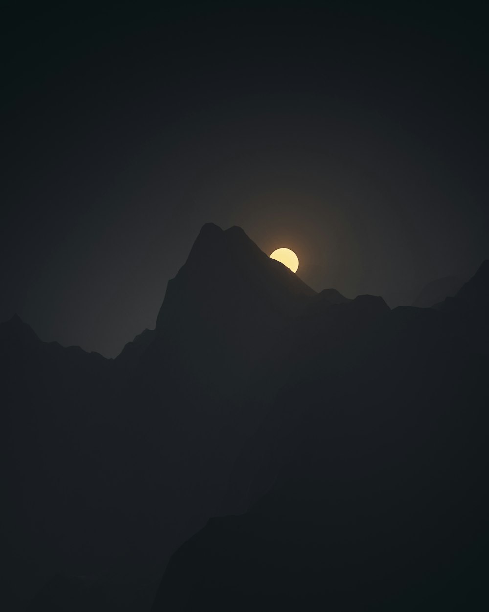 the sun is setting over a mountain range