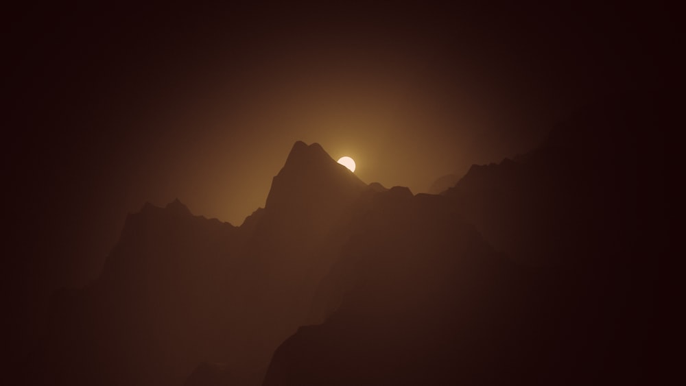 the sun is setting over a mountain range