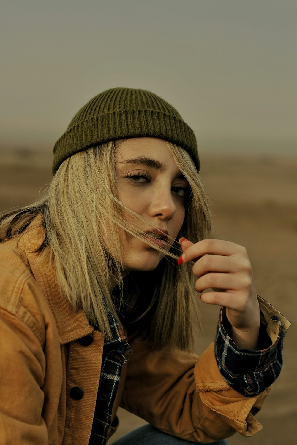 Eine Frau sitzt mit einer Zigarette im Mund auf dem Boden