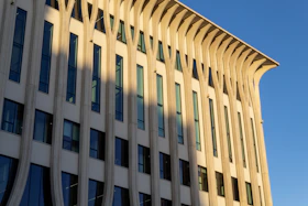 A digital rendering of a contemporary building facade highlighting texture and light play.