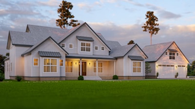a large white house sitting on top of a lush green field