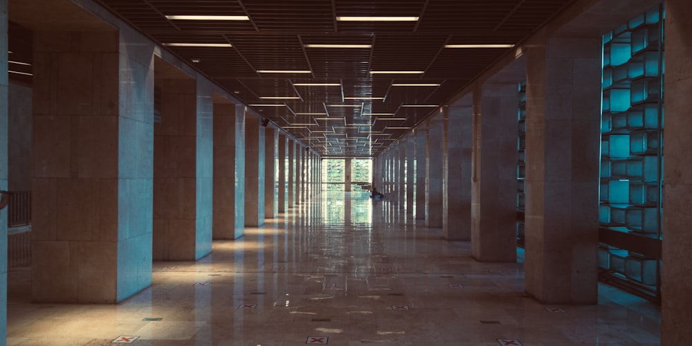 a long hallway in a building with columns