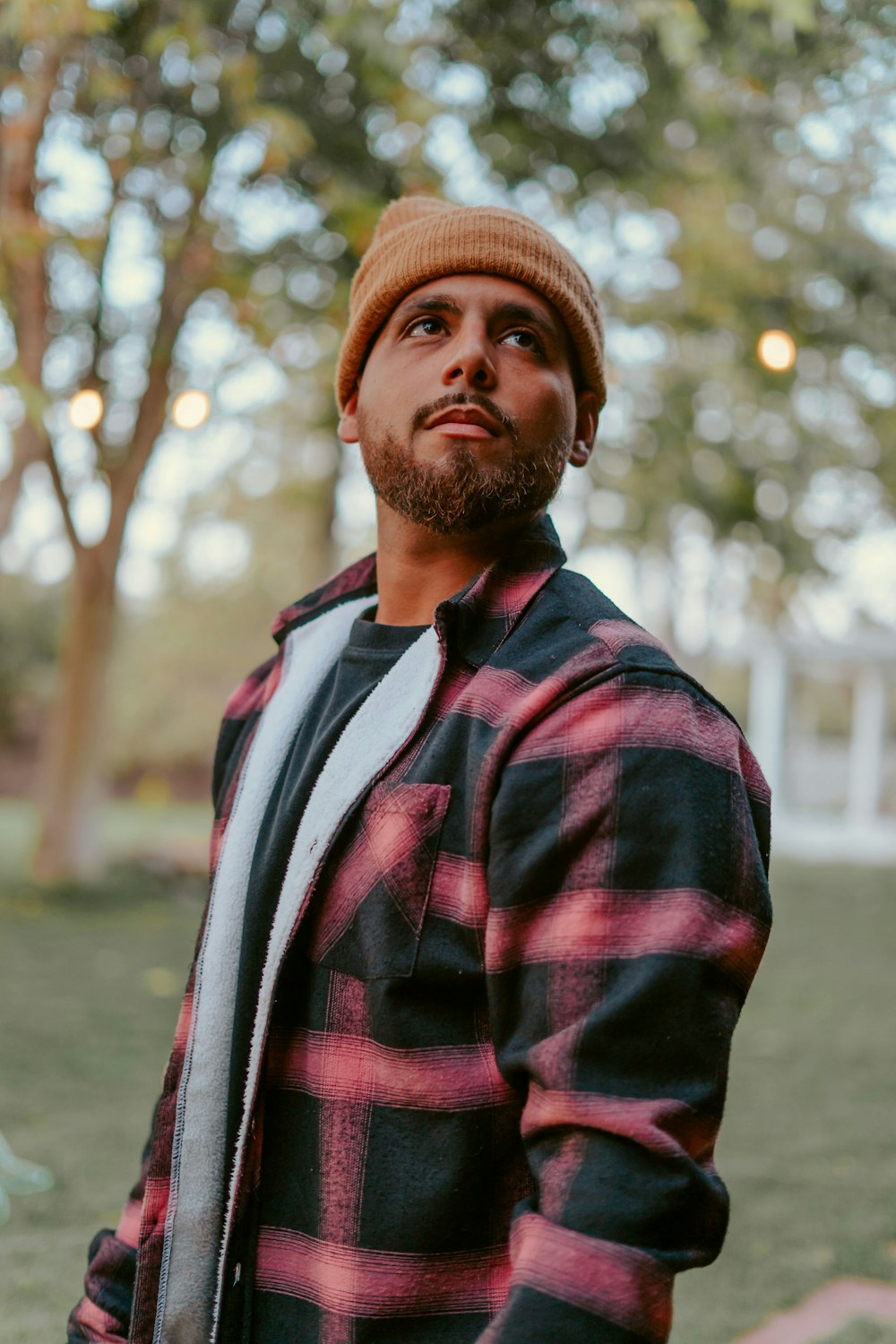 Un hombre con barba con una camisa de franela roja y negra