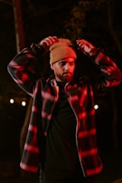 a man wearing a hat and jacket in the dark