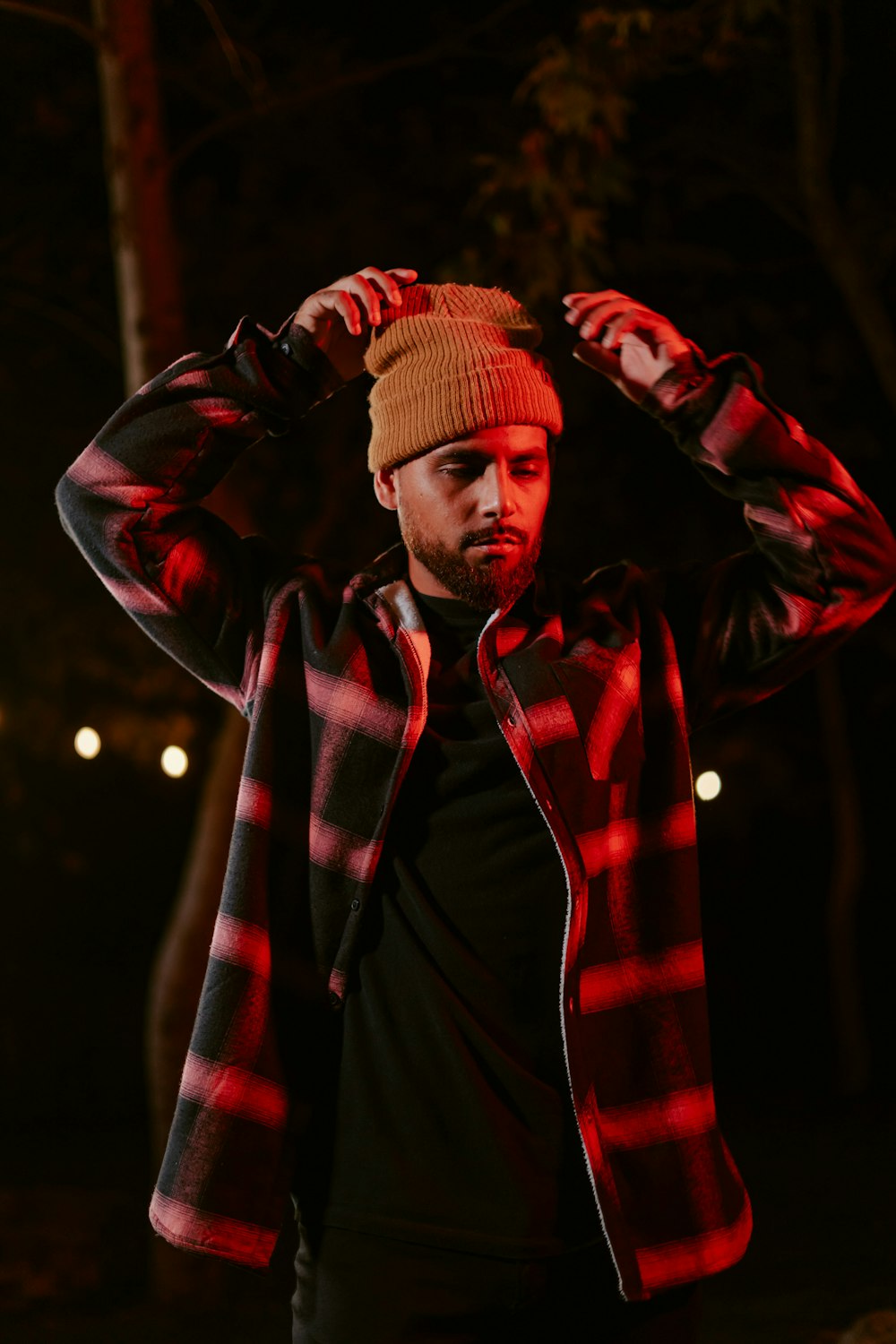 a man wearing a hat and jacket in the dark