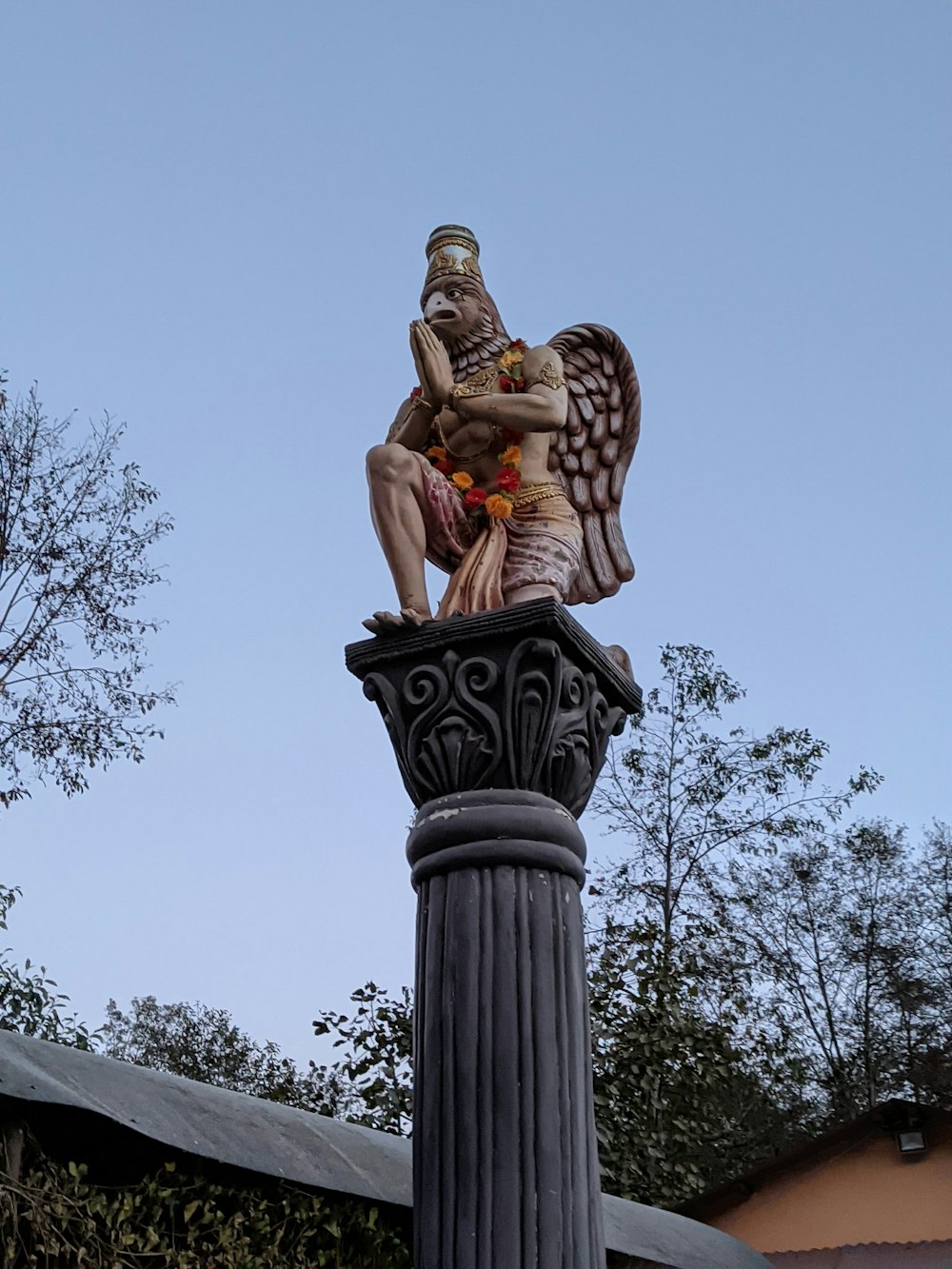 a statue of a man sitting on top of a pillar