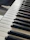 A close-up of polished piano keys with sunlight streaming through a nearby window.