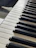 A close-up of polished piano keys with sunlight streaming through a nearby window.