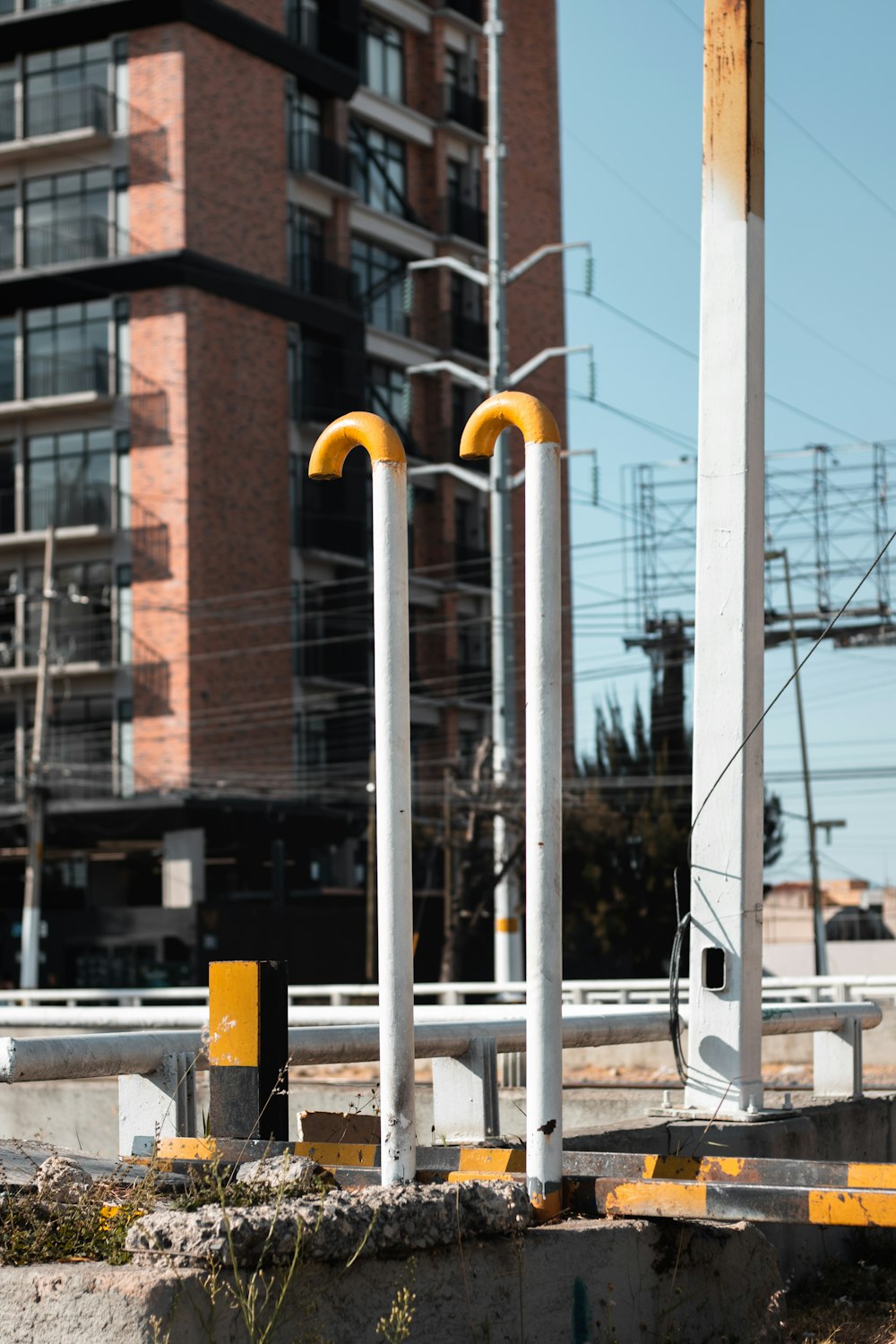 three yellow and white poles in front of a building