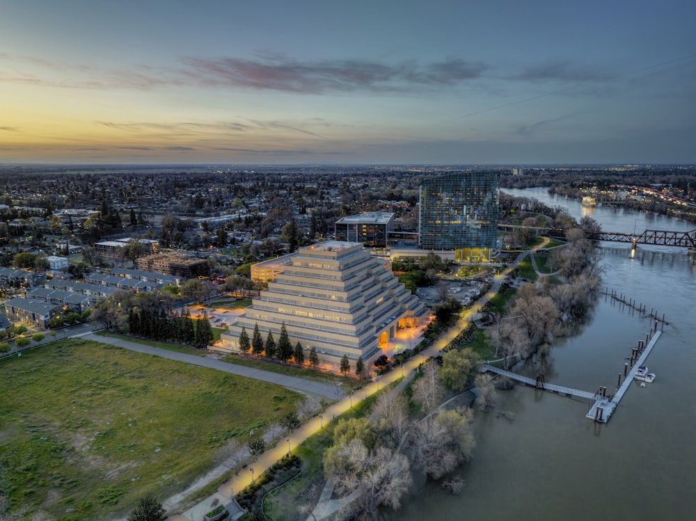 an aerial view of a building next to a body of water