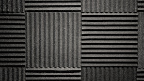 Close-up of textured acoustic wall panels in a soft beige tone, highlighting their sound-absorbing surface.