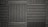 A pattern of black acoustic foam panels arranged in a grid. Each panel features alternating horizontal and vertical grooves, creating a textured appearance that absorbs sound. The lighting emphasizes the texture and depth of the grooves.