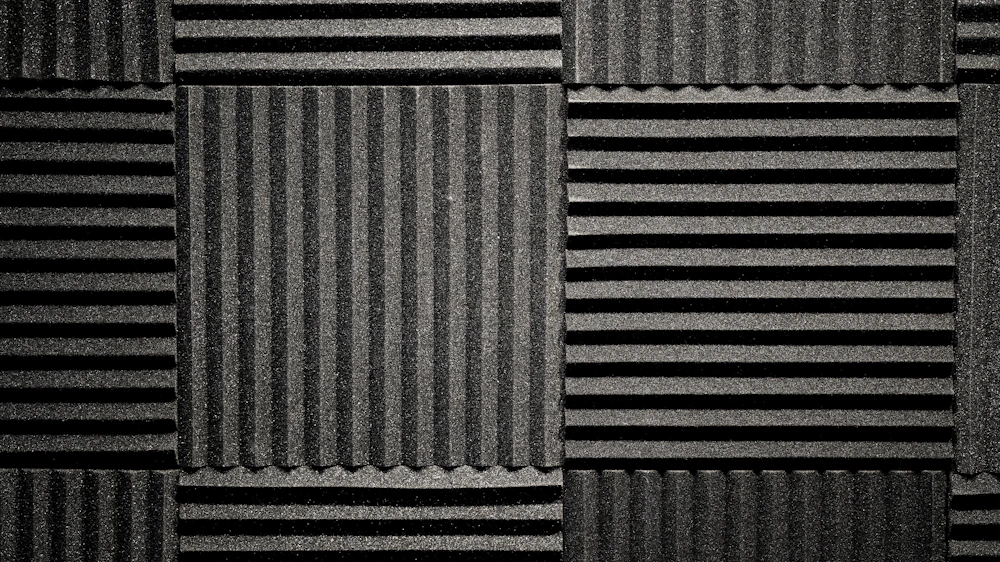 A wall of charcoal acoustic treatment panels in a studio