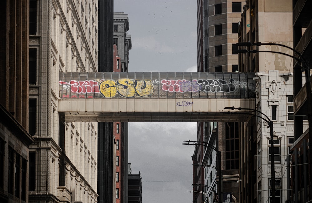 a city street with a bridge that has graffiti on it