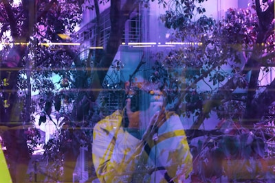 A candid shot of an art director capturing a moment with a camera amidst a colorful urban backdrop.