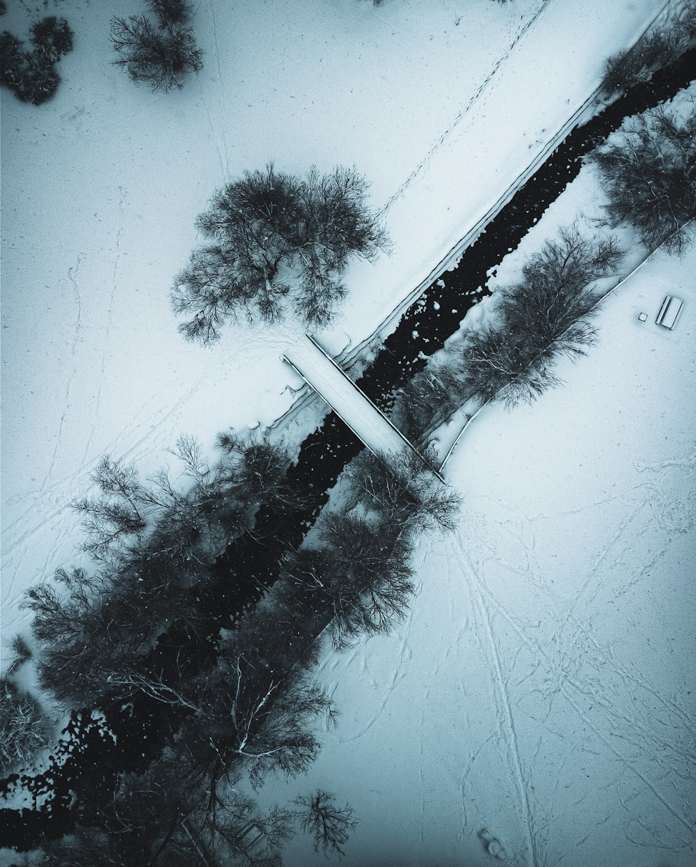 an aerial view of a snow covered road and trees