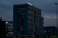 Evening shot of a completed building illuminated by warm lights.