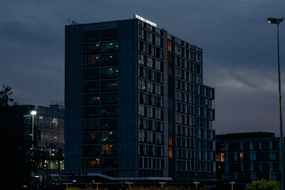 An exterior shot of a business center building glowing warmly at dusk.
