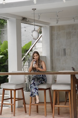 a woman sitting at a table using a cell phone