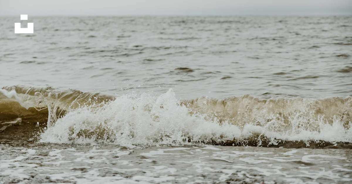 A large body of water with waves coming in to shore photo – Free Nature ...