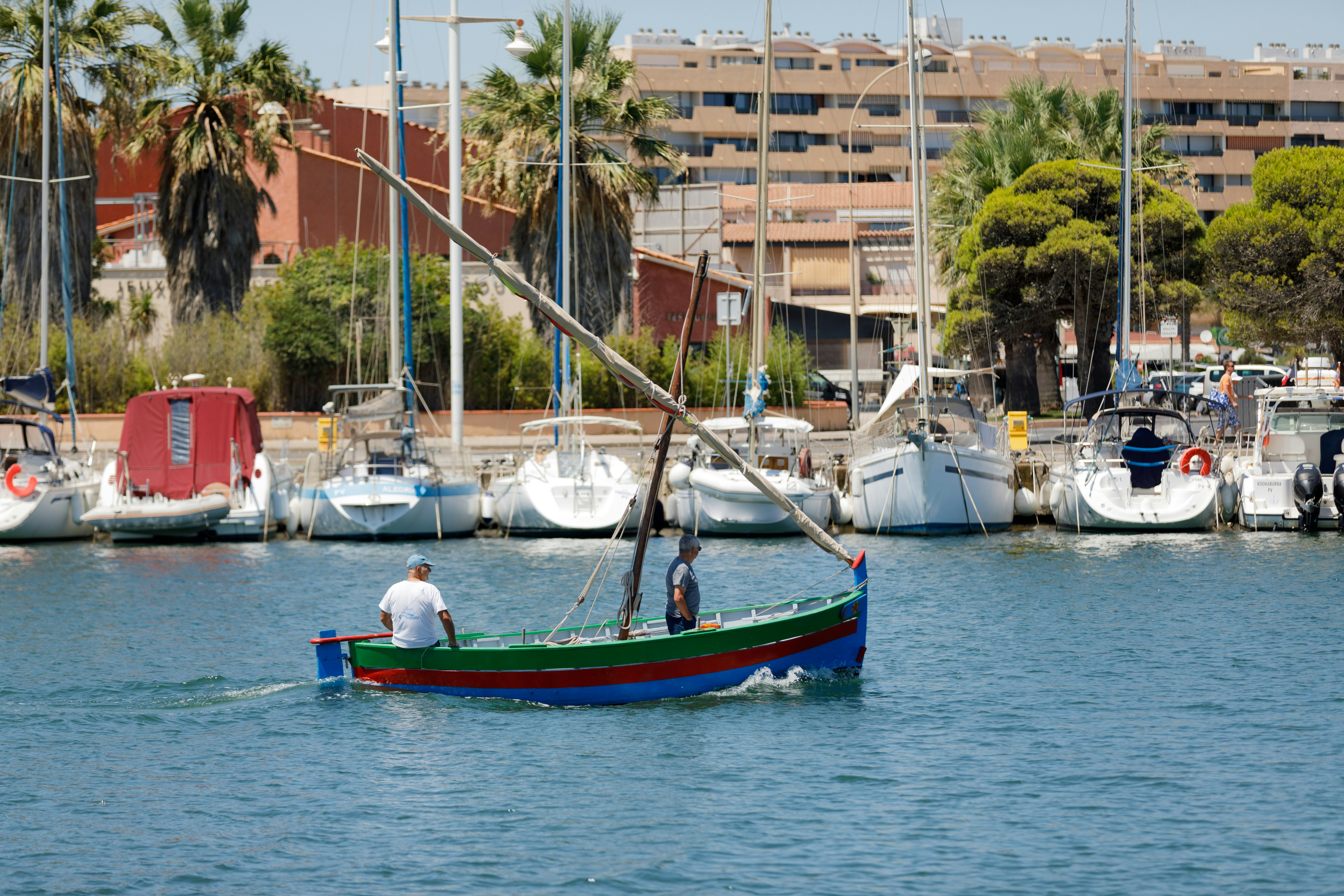 a man in a green and red boat in the water