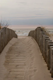 Sunlit sandy path leading from the cozy house to the calm Naiyang Beach shore.