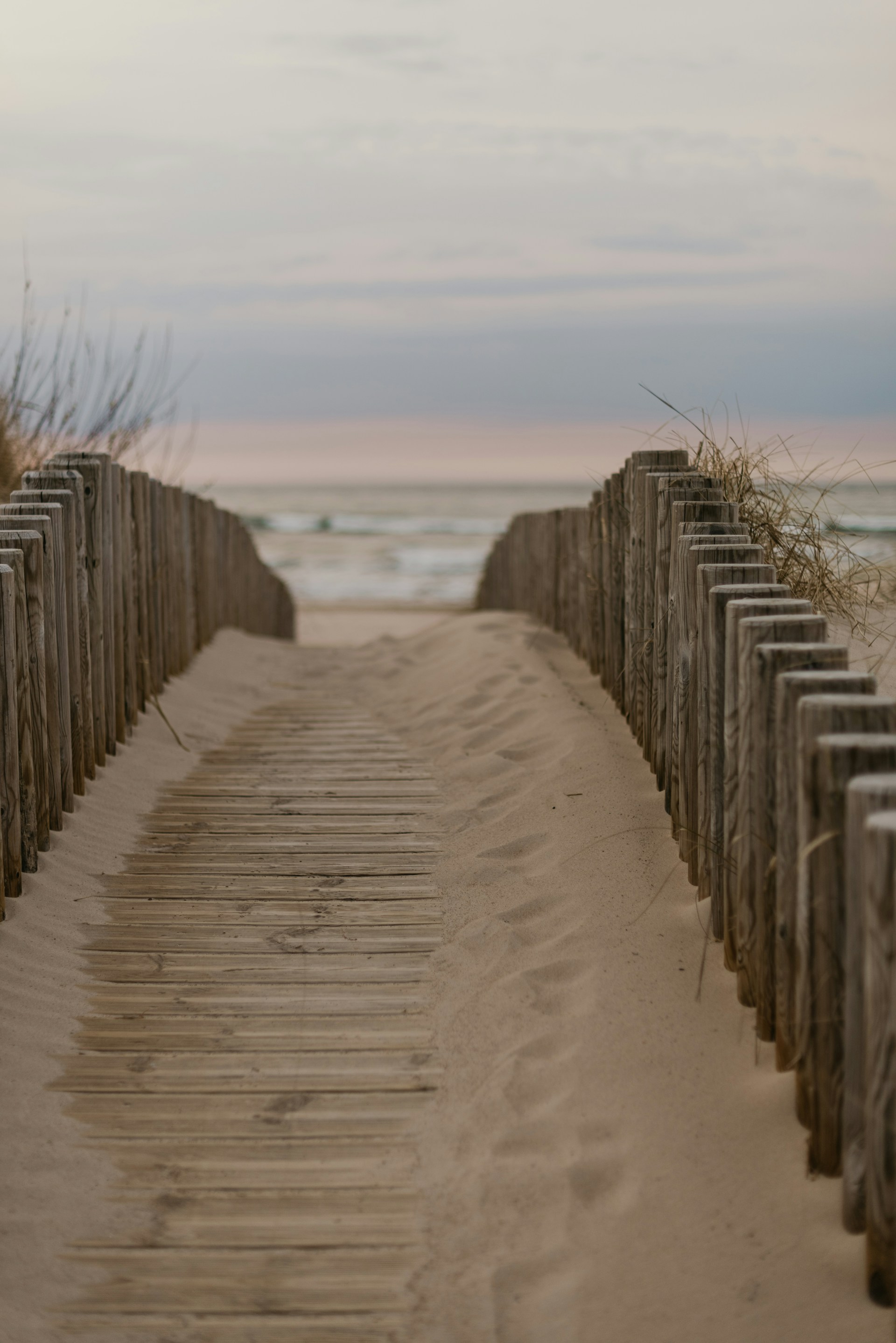 Wide shot of the sandy path leading directly from the pousada to the calm, blue waters of Geribá beach