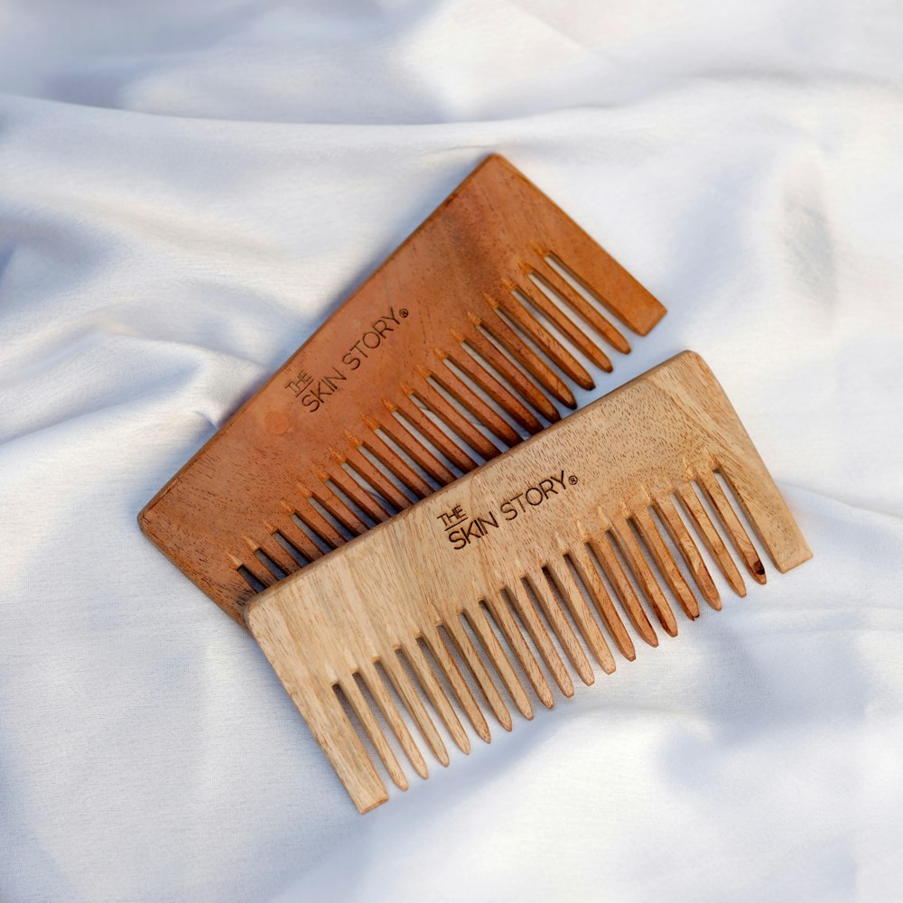 a couple of wooden combs sitting on top of a white sheet