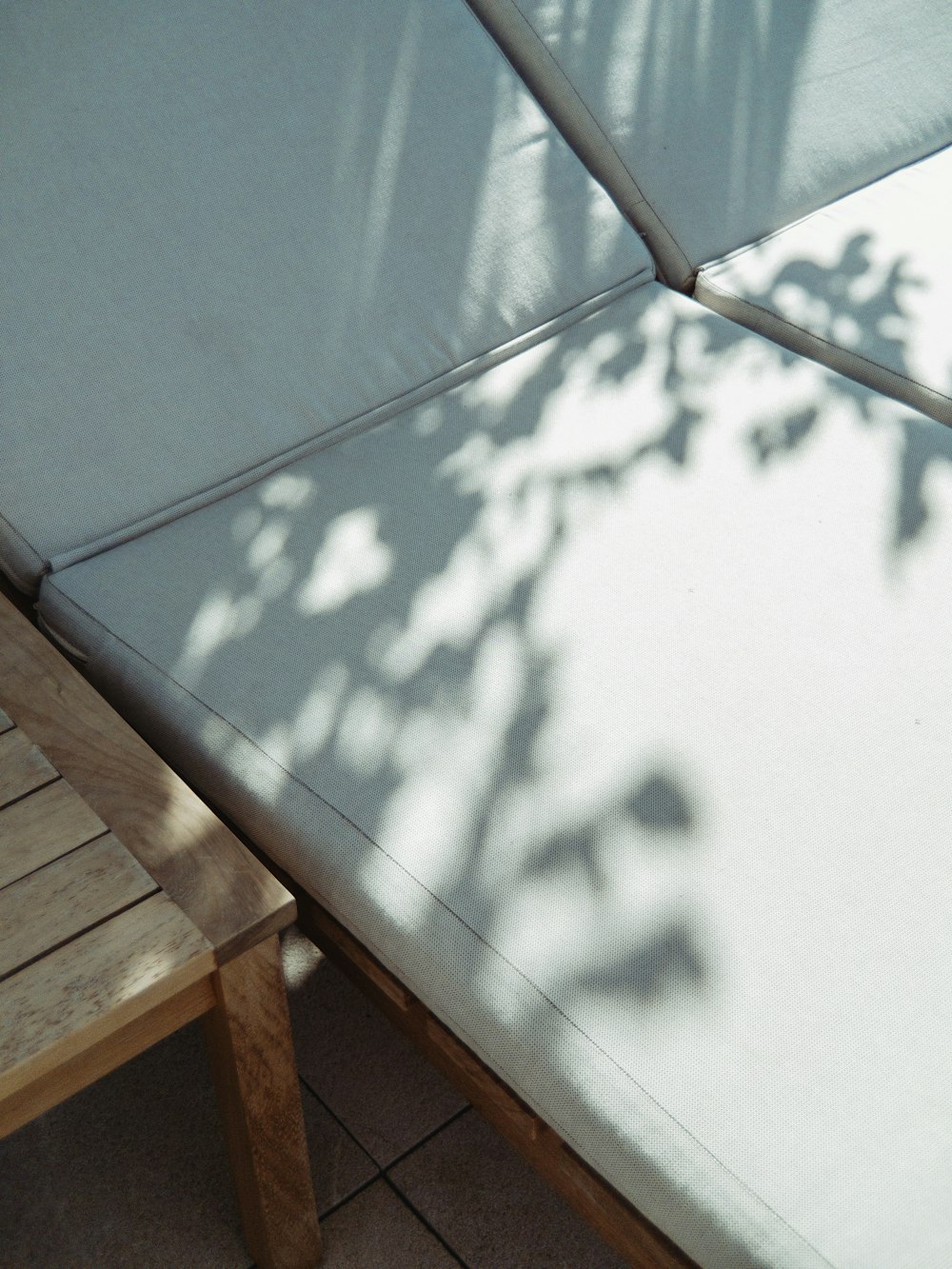 a wooden bench with a mattress on top of it