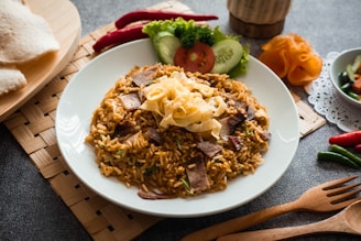a white plate topped with rice and meat