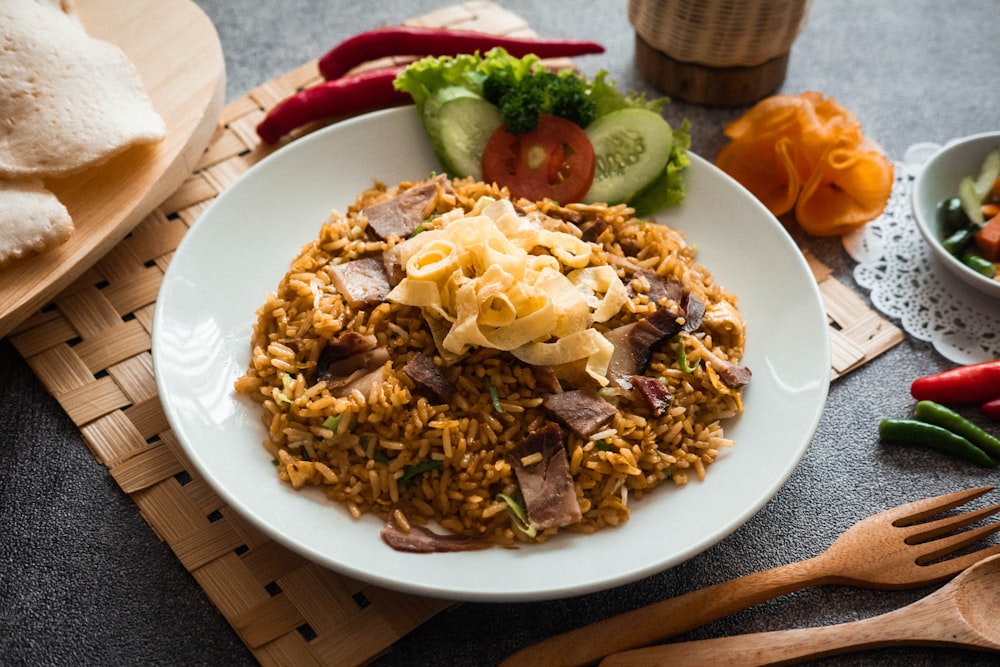 a white plate topped with rice and meat