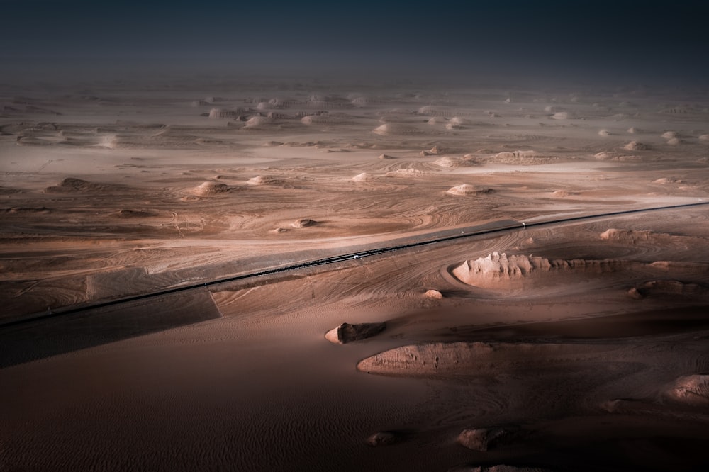 an aerial view of a desert with a road running through it