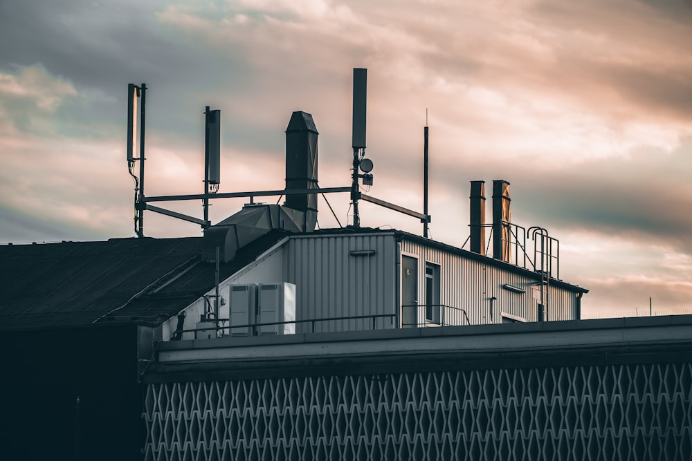 a smokestack on top of a building with a cloudy sky in the background