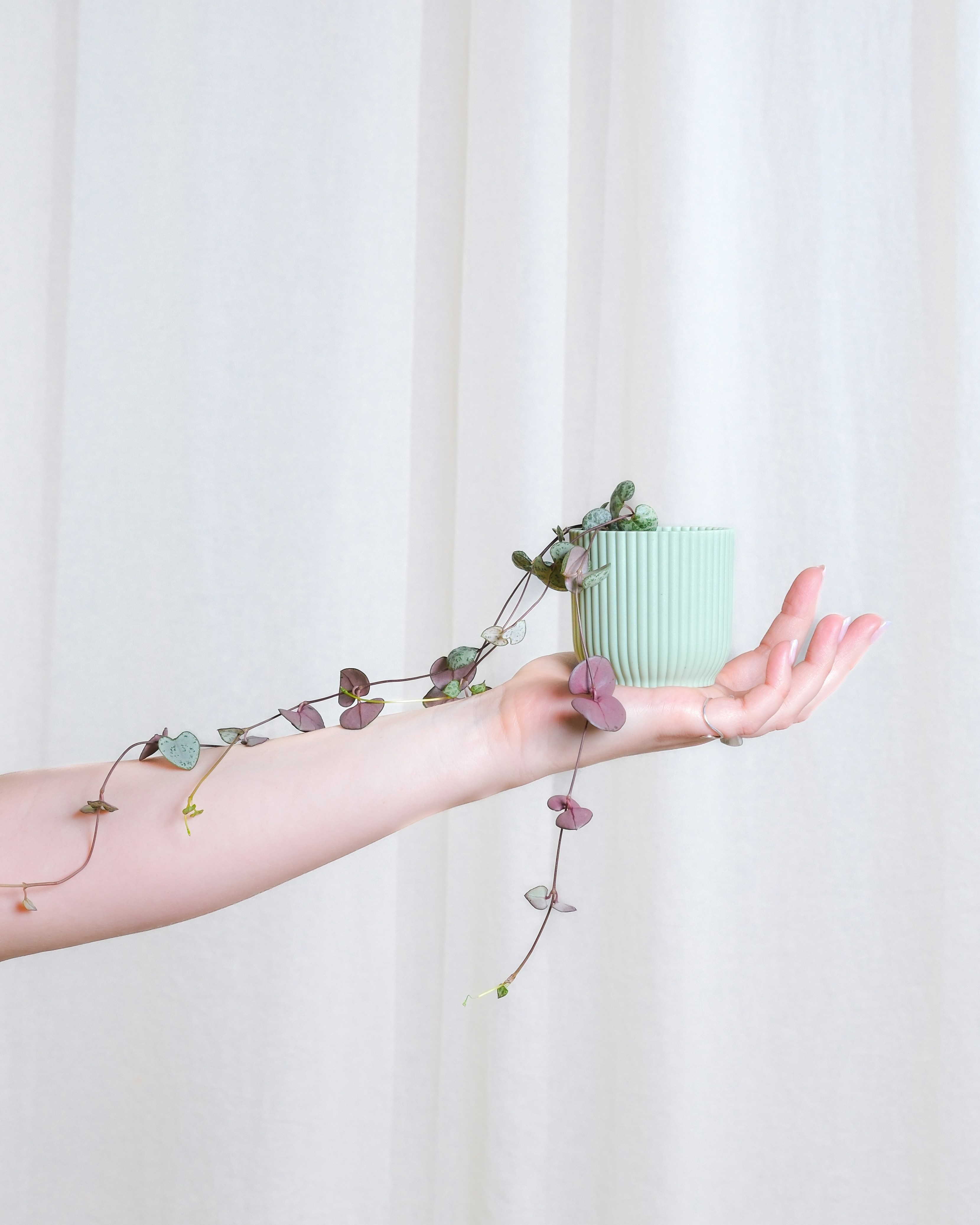 a woman holding a cup with a plant growing out of it