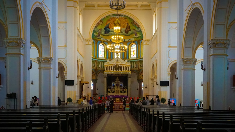 a church filled with lots of pews and a chandelier