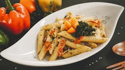 a white plate topped with pasta and vegetables