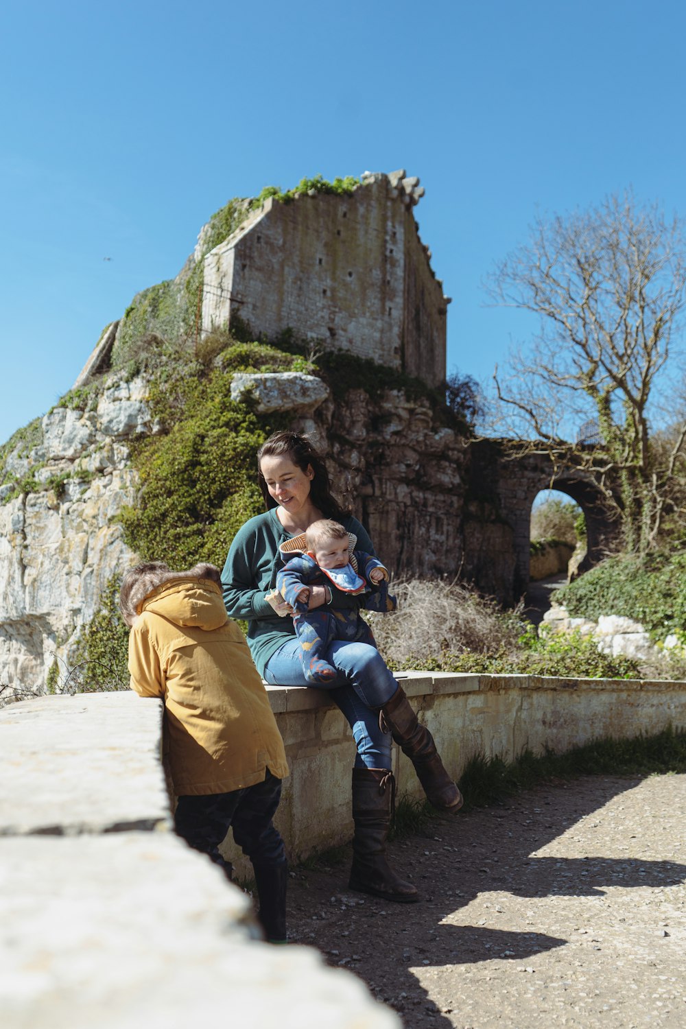 a woman and a child are sitting on a wall