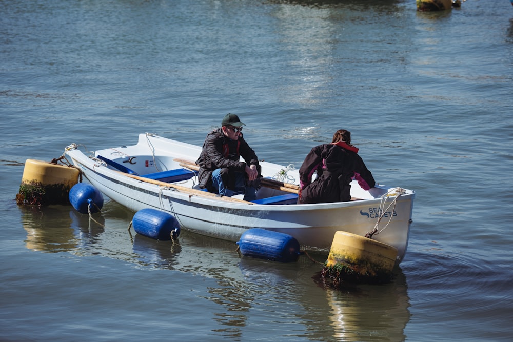 two people in a small boat in the water