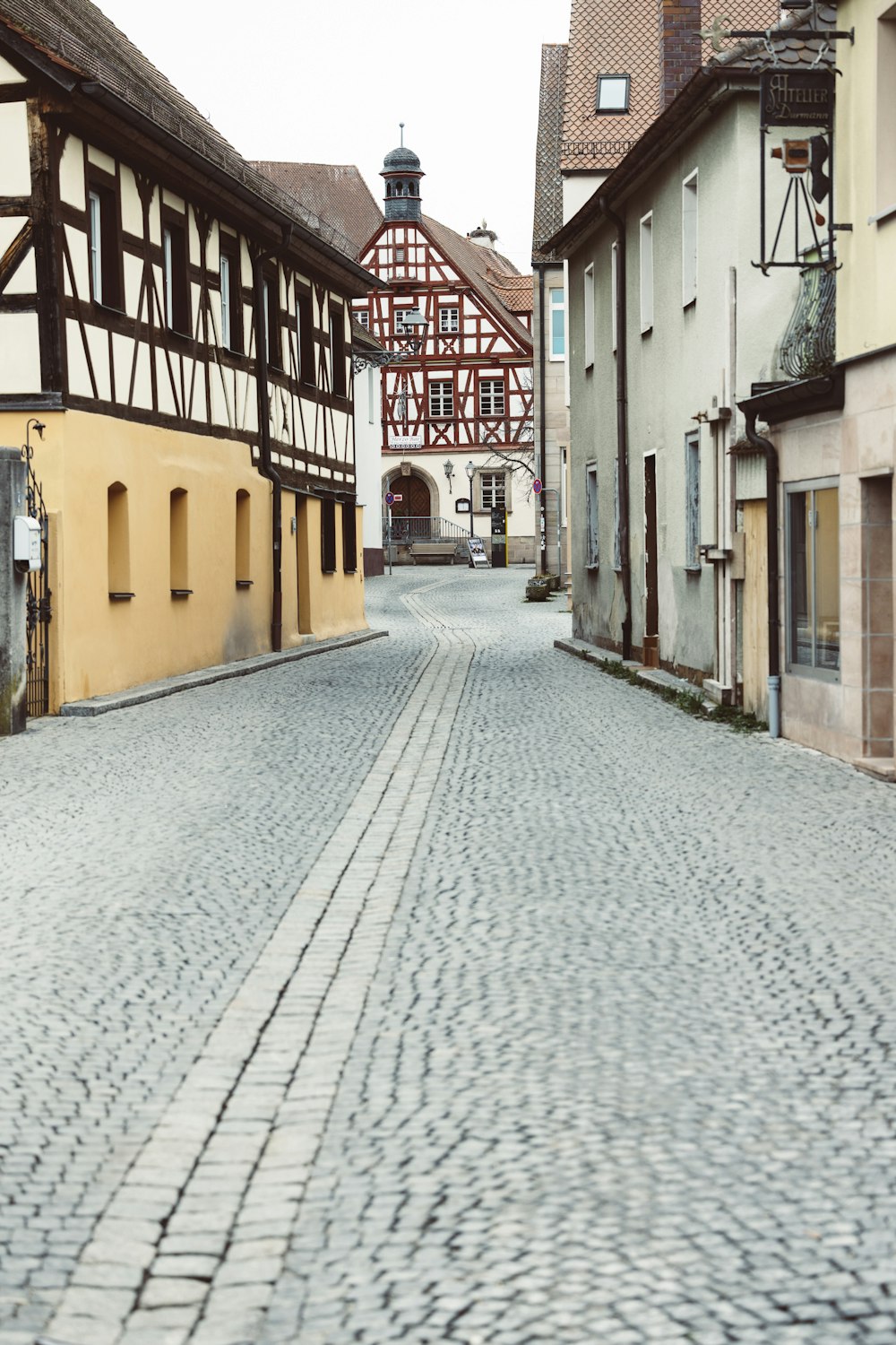 a cobblestone street with a clock tower in the background