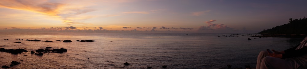 a person sitting on a bench looking out at the ocean