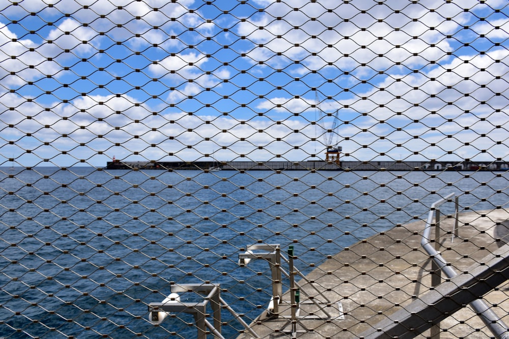 a view of a ship through a chain link fence