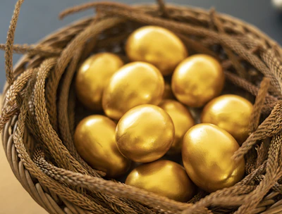 a basket filled with gold colored eggs on top of a table