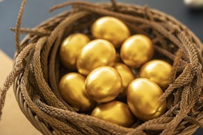 a basket filled with gold colored eggs on top of a table