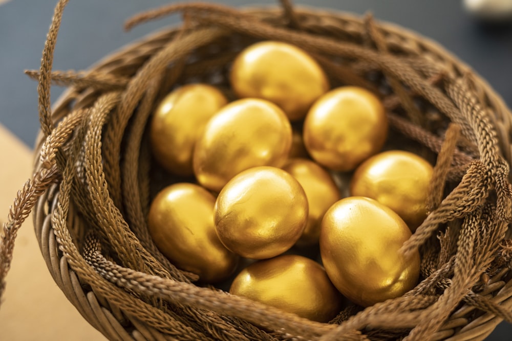 un cesto pieno di uova color oro in cima a un tavolo