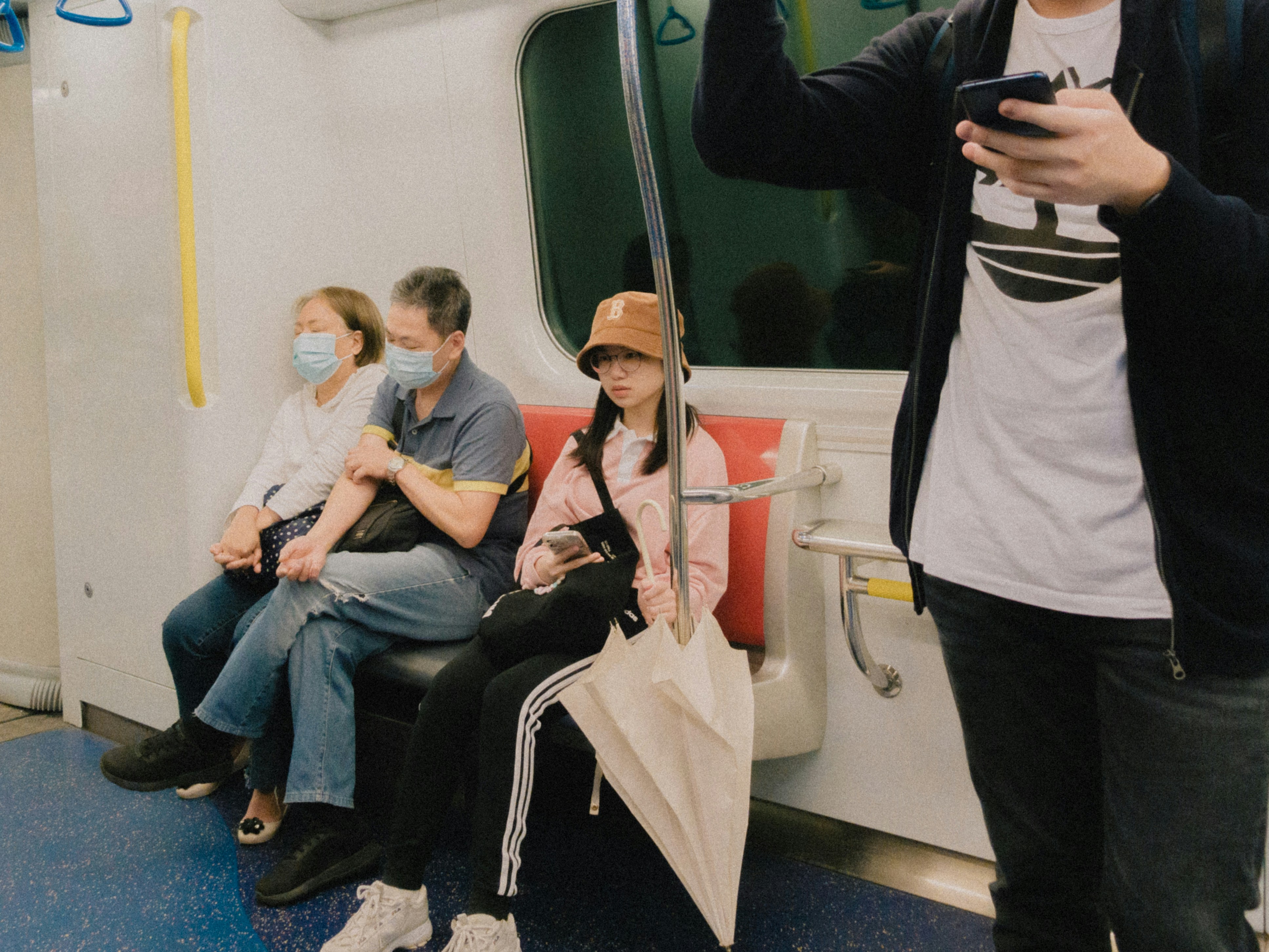 a group of people sitting on a subway train (Photo by Catgirlmutant on Unsplash)