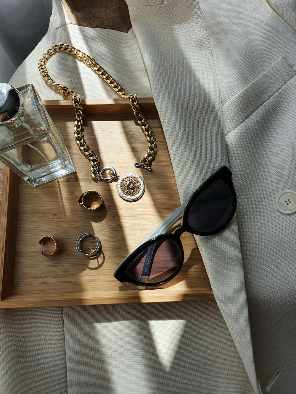 a tray with sunglasses, a bottle of water and a watch