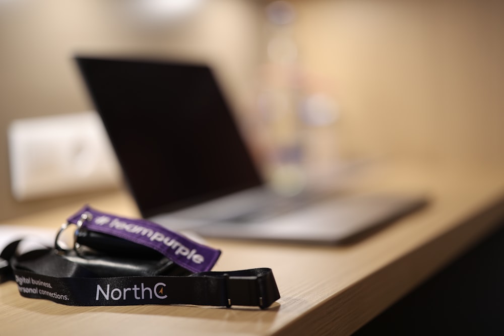 a lanyard sitting on top of a desk next to a laptop