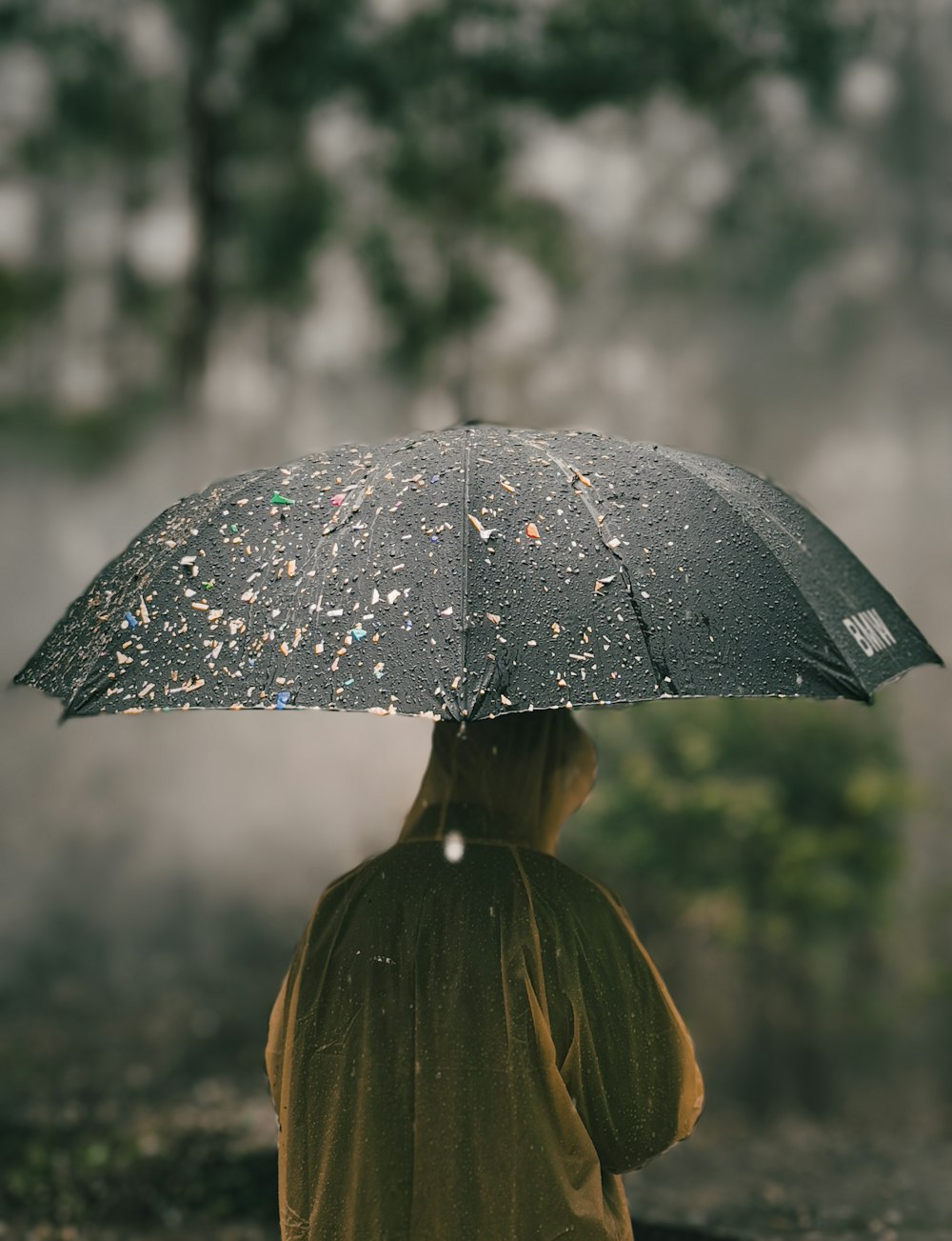 a person standing under an umbrella in the rain