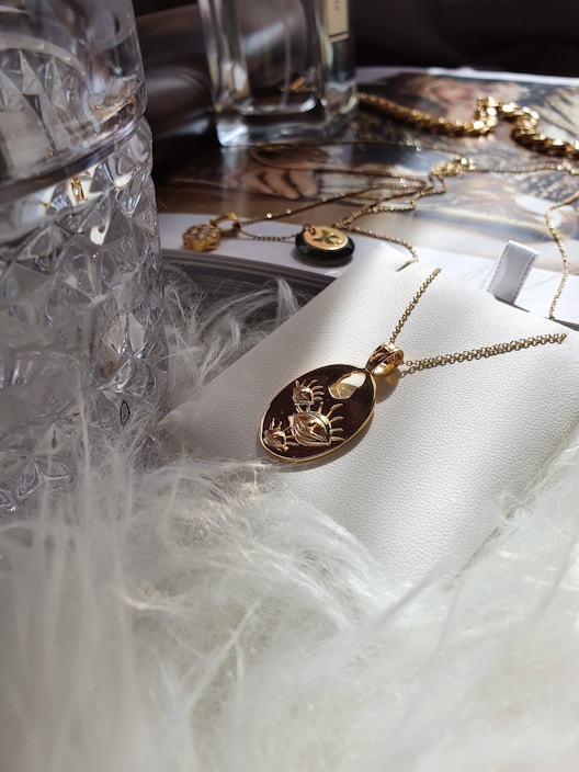 Close-up of a delicate gold necklace with a sparkling pendant on a soft velvet background