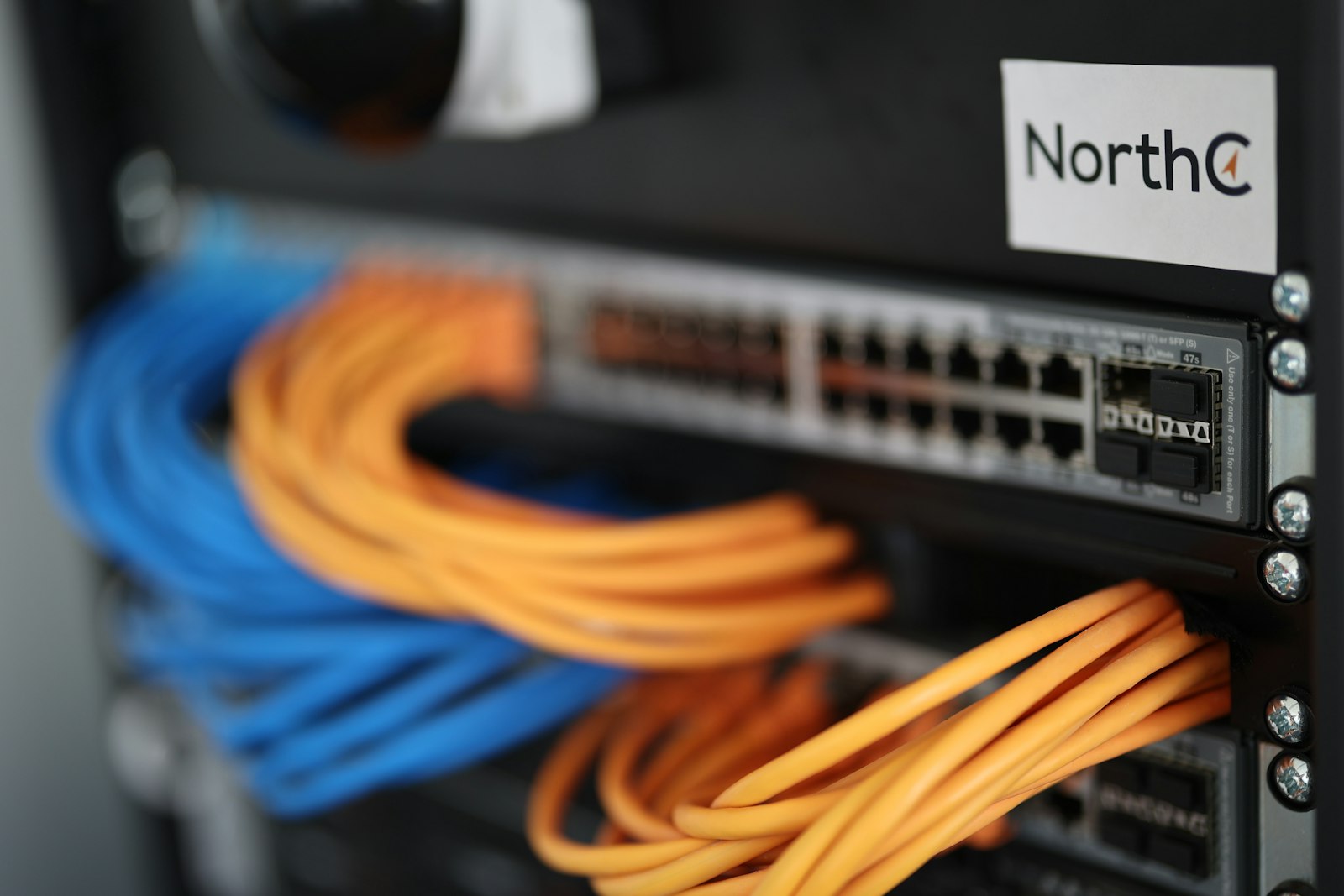 Network switch and PoE cabling in a Brisbane server rack powering IP security cameras